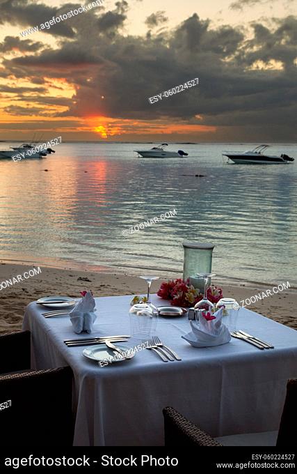 Festlich gedeckter Tisch am Strand bei Sonnenuntergang in Le Morne, Mauritius, Afrika. Table set for a romantic dinner at the beach during sunset in Mauritius