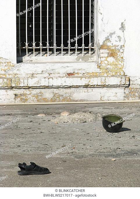 soldier's old helmet and sandal in front of abandoned casern, Haiti, Province de l'Ouest, Port-Au-Prince