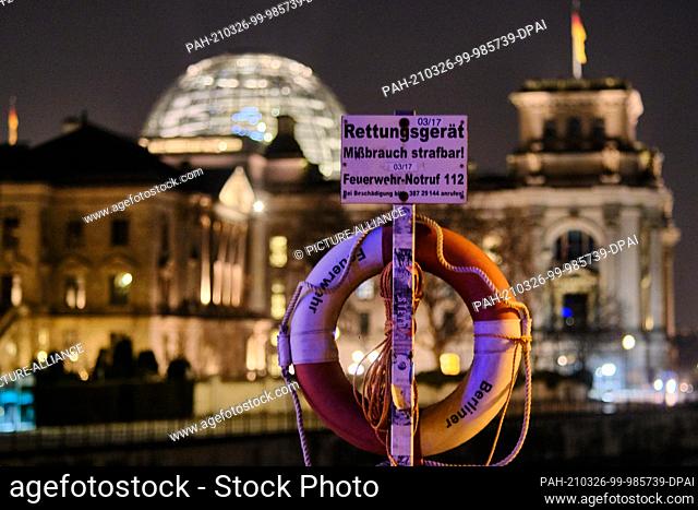 24 March 2021, Berlin: A sign with the inscription ""Rescue equipment abuse punishable! Fire emergency call 112"" and a life ring stand on the Marschall Bridge