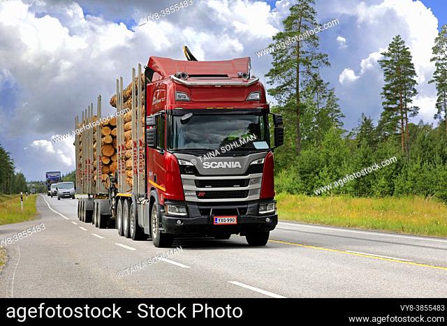 Red Scania R540 XT logging truck of Kuljetus Simo Iitti Ky pulls pine log load along highway 25 in the summer. Raasepori, Finland. July 24, 2020