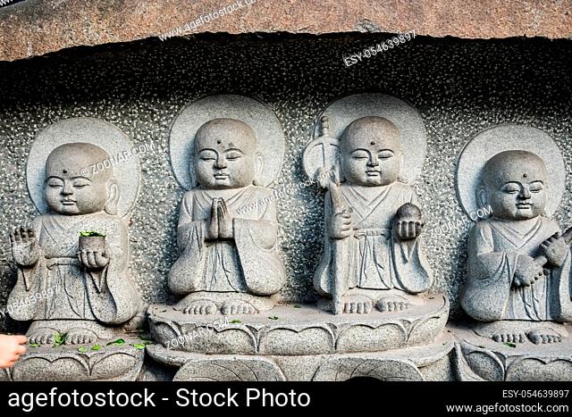 Four small holy buddhist sculptures carved on a temple wall in Wenshu Monastery, Chengdu, China