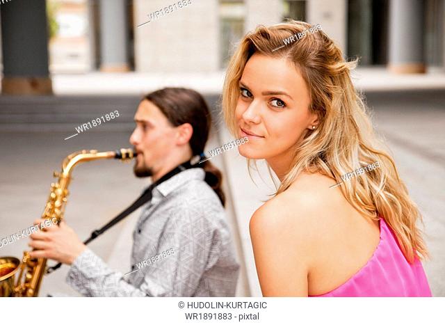 Man playing the saxophone to woman, Osijek, Croatia