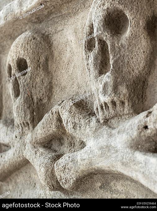 Skulls and crossbones carving on a cemetery wall