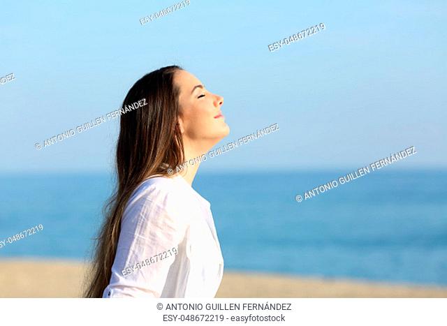 Side view portrait of a woman relaxing breathing fresh air on the beach