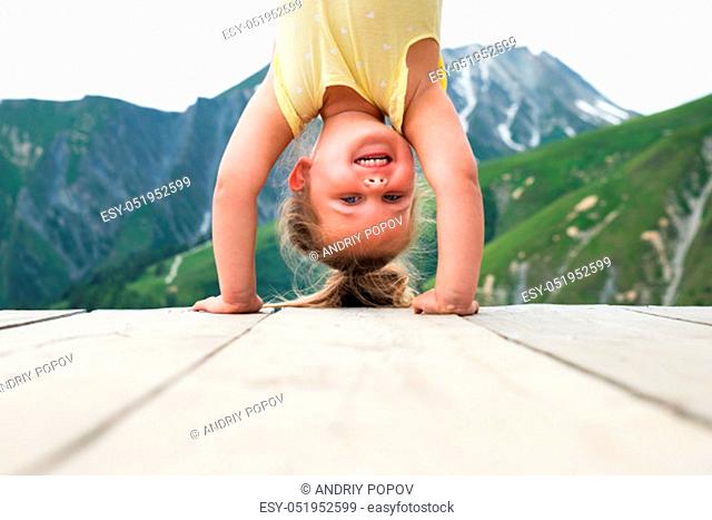 Little Girl Standing On Her Head In Mountains