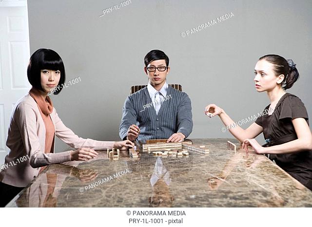 two fashionable women and a man playing mahjong