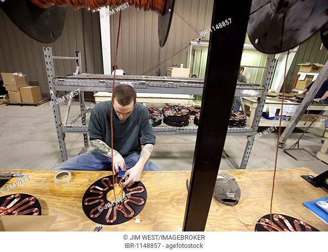 Worker assembles the generators of Windspire wind turbines; the Windspire is a small, vertical axis wind turbine designed for residential or small business use
