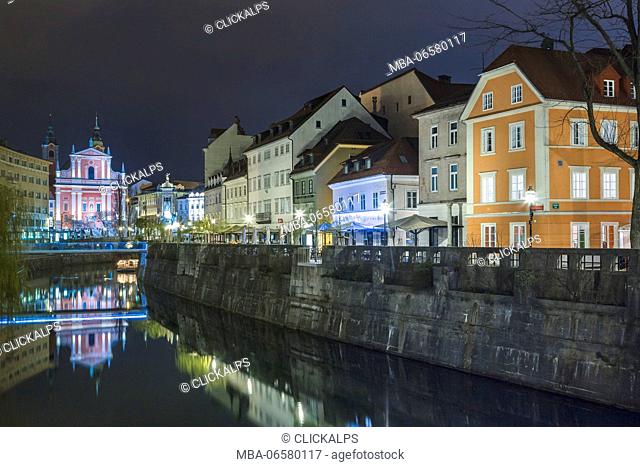Europe, Slovenia, Ljubljana, Buildings on the Ljubljanica river, on the background the Franciscan Church of the Annunciation