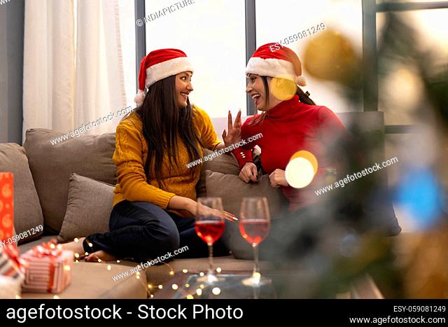 young women celebrating Christmas wine party at home
