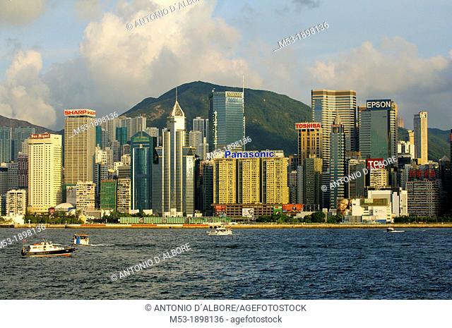 Commercial buildings in Admirality and Wanchai on Hong Kong island at sunset  In foregrounds the waters of Victoria Habor  Hong Kong  China