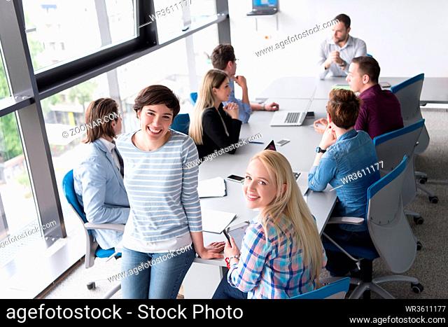 Business Women Using Digital Tablet in Busy Office