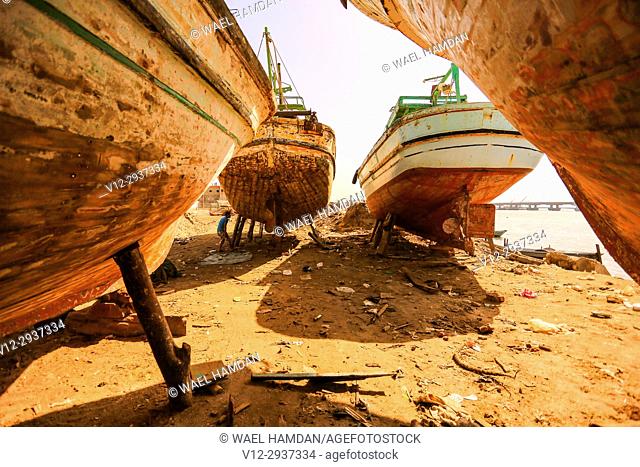 Painting work on new wooden boats on a dry dock, El-Burullos, Kafr El-Sheikh, Egypt, Africa