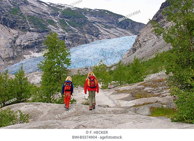 two children wandering to Nigardsbreen glacier arm, Norway, Jostedalsbreen National Park