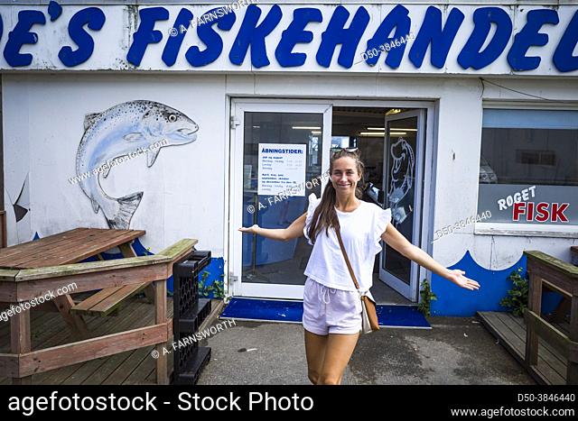 Hirtshals, Denmark July 8, 2021 A young woman posing in front of a local fish store