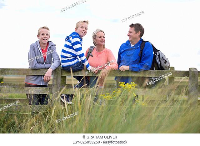 Happy Family of Four on a bridge. They are wearing casual clothing and looking at the surrounding area