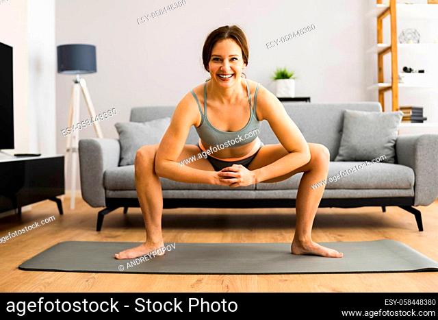 Fitness Woman Doing Leg Stretching Exercise At Home