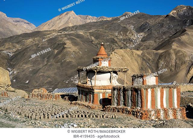 Buddhist stupas in front of mountain landscape, prayer or reliquary shrine, dried mud or adobe bricks on the ground, Tangge, former Kingdom of Mustang, Nepal