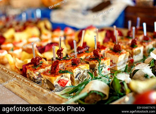 Tasty snack at the buffet table on a wooden tray