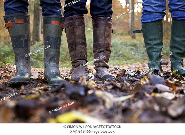 Three women in wellington boots in a forest