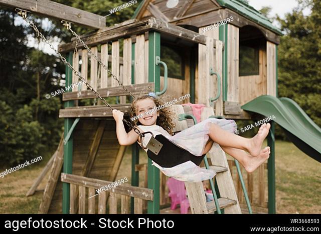 Happy little girl on a swing