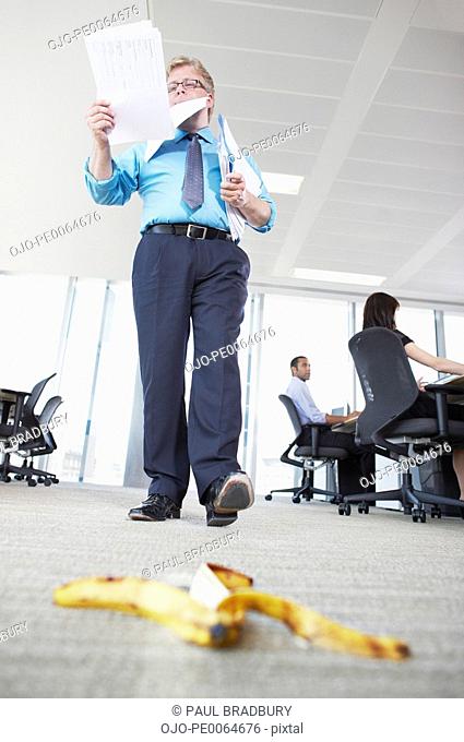Businessman about to step on banana peel