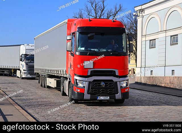 Red Renault Trucks T semi trailer driving on cobbled Helsinki street after arrival in Port of Helsinki, Finland on sunny day of spring. April 7, 2020