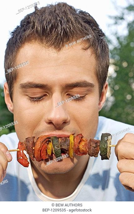 Boy eating shashlik