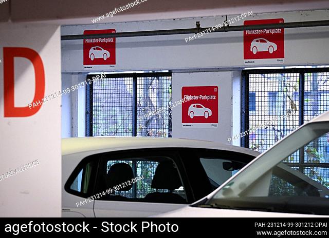 14 December 2023, Brandenburg, Potsdam: Signs with the red logo for ""Flinkster-Parkplatz"" are displayed in front of a parking bay in the parking garage at the...