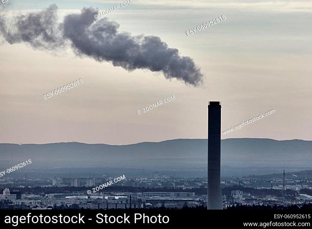 Smoking rizing from industrial chimney in an urban environment