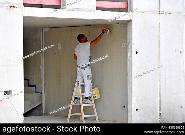 Construction workers on a large construction site, workers grouting concrete walls, prefabricated walls. New apartments, shell construction, scaffolding