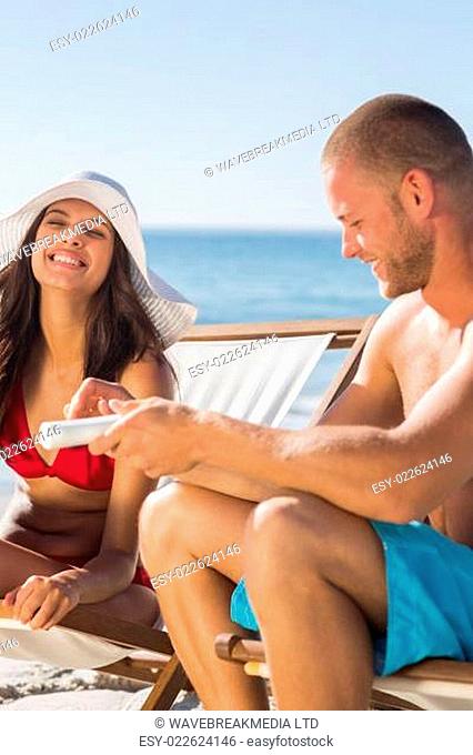 Attractive man applying sun cream on his girlfriend