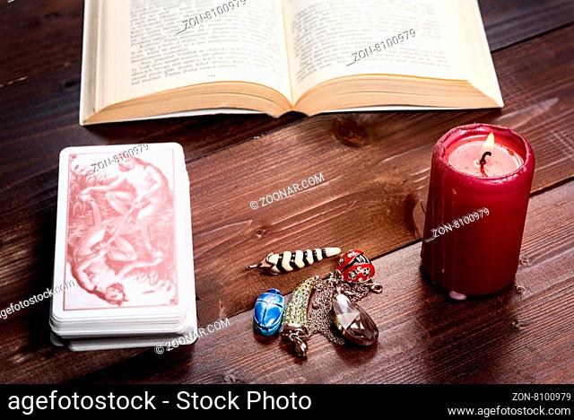 Composition of esoteric objects, candle, cards and book used for healing and fortune-telling