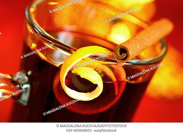 Mulled wine with lemon peel and cinnamone stick on glass. Selective focus, shallow DOF