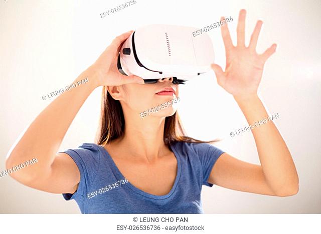 Woman watching though VR device and hand touch on something