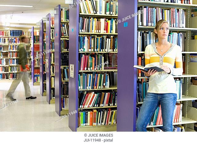 Woman with book in library