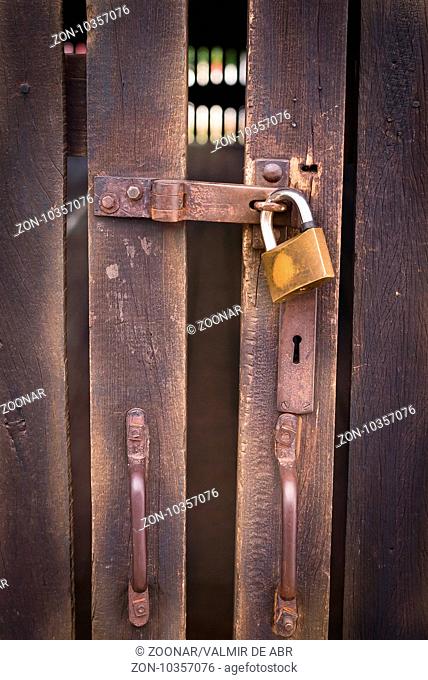 Close up view of a padlock and old wooden door
