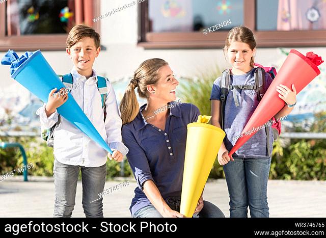 Mother and children on first day at school with candy cones