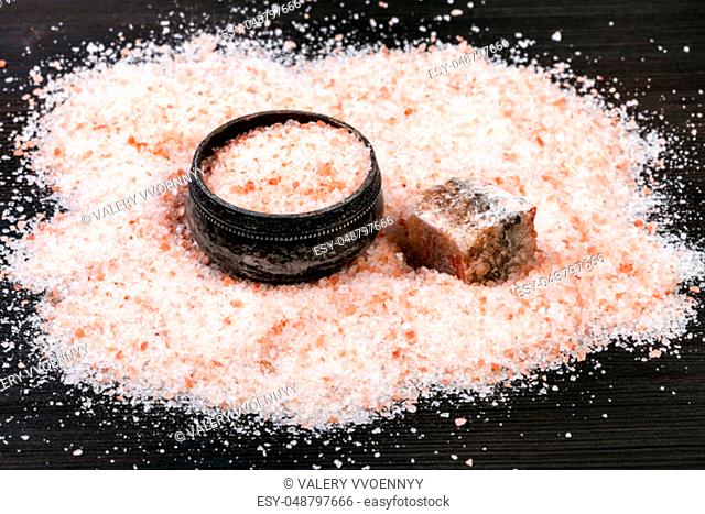 old silver salt cellar, raw natural pink Halite mineral and grained Himalayan Salt on dark brown wooden board