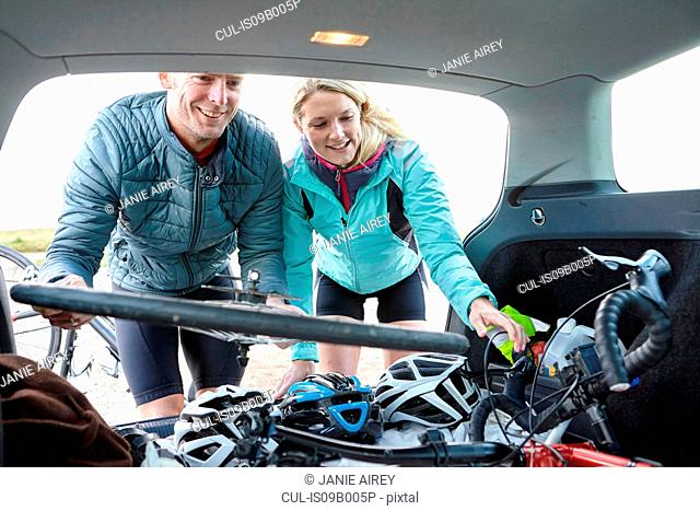 Cyclists removing bicycle from vehicle