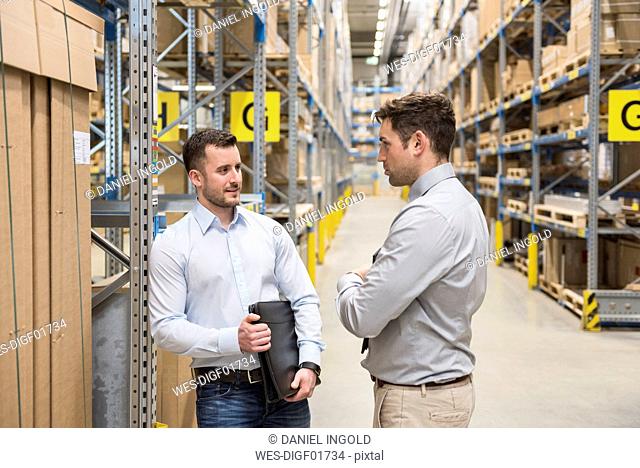 Two men talking in factory warehouse