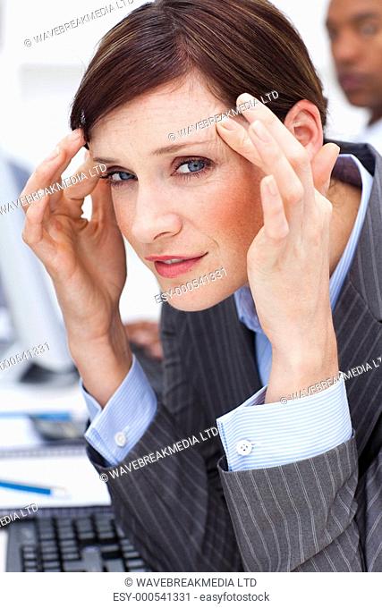 Young businesswoman having a headache in the office