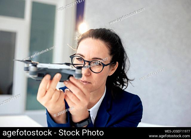 Businesswoman with eyeglasses looking at drone