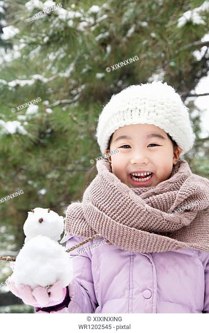 Girl Holding a snowman in a park