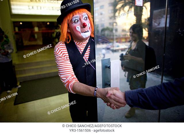 A clown shakes hands with a photographer during the 16th International Clown Convention: The Laughter Fair organized by the Latino Clown Brotherhood