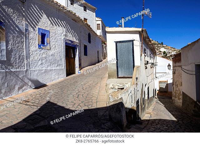 Narrow street with white painted houses, typical of this town, take in Alcala of the Jucar, Albacete province, Spain