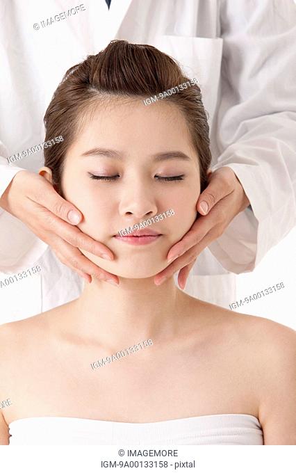 Beautiful young woman getting face massage
