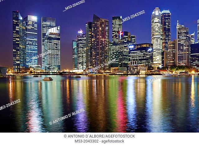 The Central Business District by night. In the foreground the water of Marina bay. Singapore