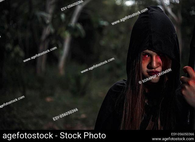 Woman ghost horror her have scythe on hand in forest, halloween day concept