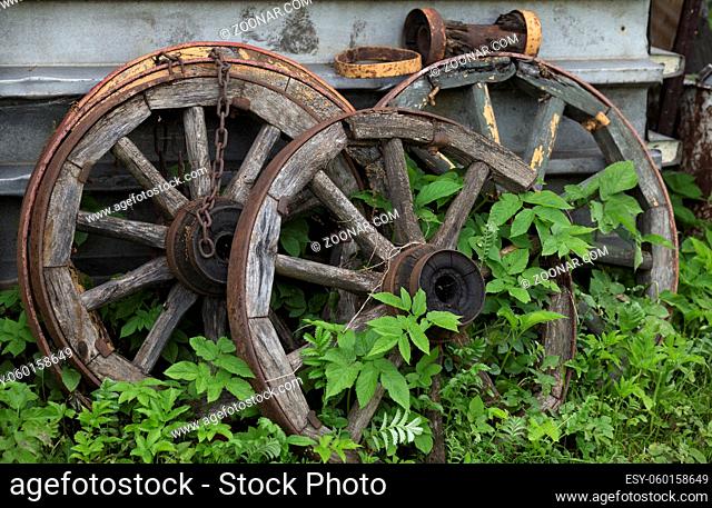 Old vintage wooden wheels in grass, rustic historical item