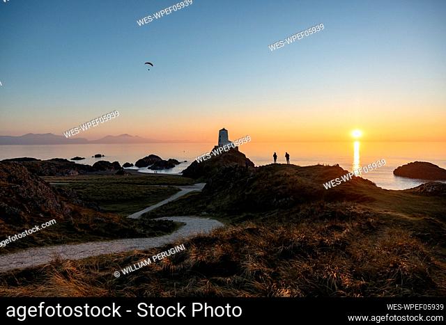 UK, Wales, Newborough, Winding footpath leading to Twr Mawr Lighthouse at sunset